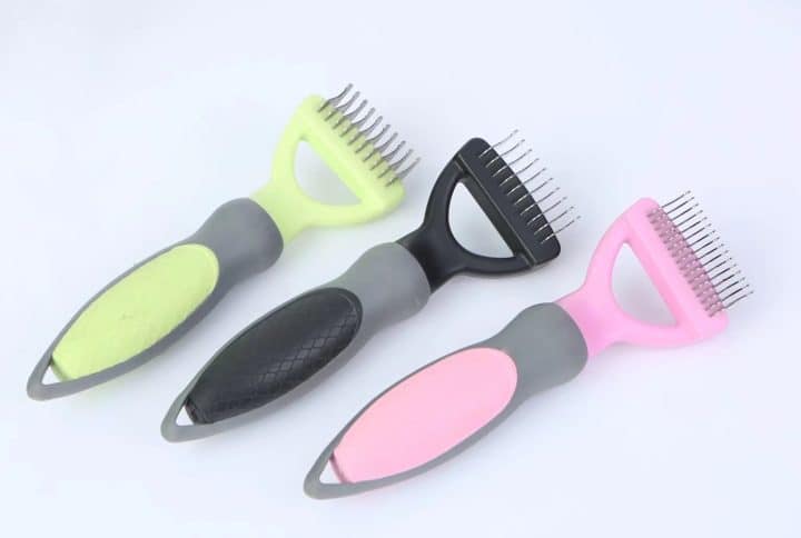 Brosses ergonomiques pour animaux de compagnie avec poignées en néon pour un démêlage efficace des poils, sur fond clair.