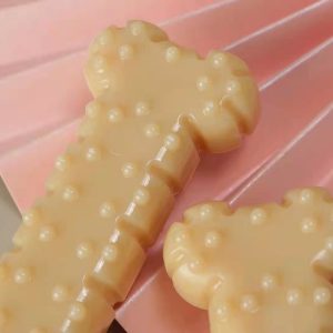 Whimsical bone-shaped treats on pink surface - playful confectionery display.