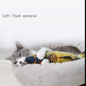 Un chat gris dans un lit en peluche avec un jouet coloré se repose confortablement.